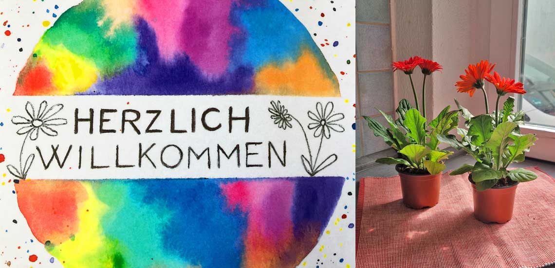 Schild Willkommen und Blumen
