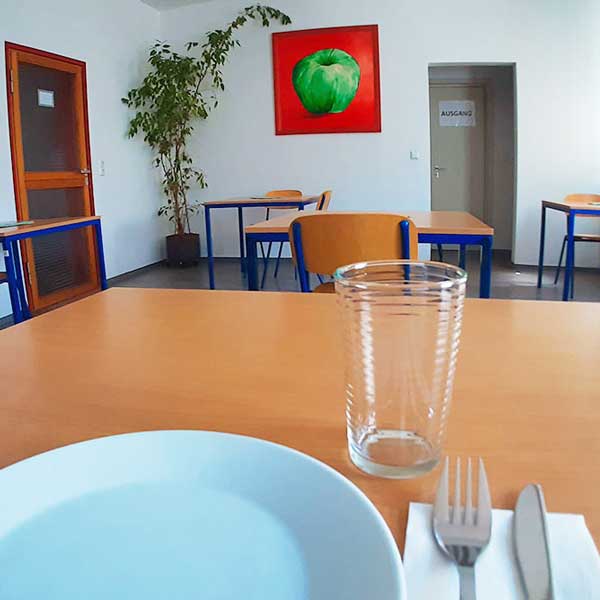 Tagesstätte - gedeckter Tisch mit Teller Messer, Gabel und Glas 