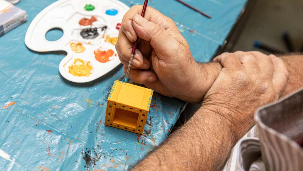 Dornahof Handwerkskunst, Mann bemalt W&uuml;rfel 